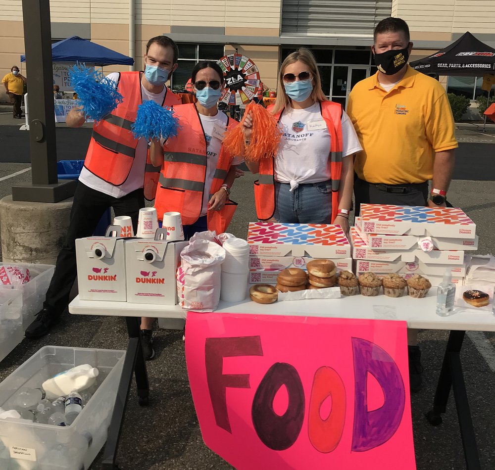 volunteers serving coffee and donuts at a Ride for Kids event