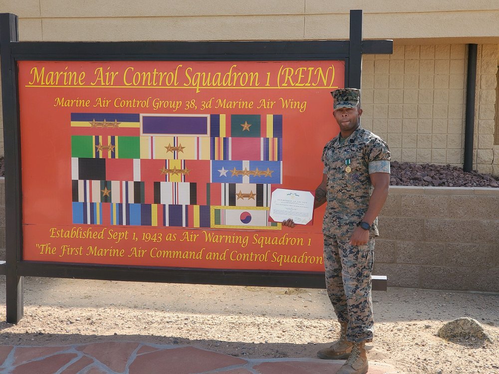Marine soldier Fred poses with his commendation medal on base.