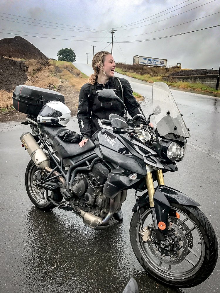 Liz Kiniery beside her motorcycle in the rain
