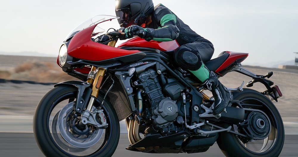 A female rider is riding the Speed Triple 1200 RR on a straight away on the race track