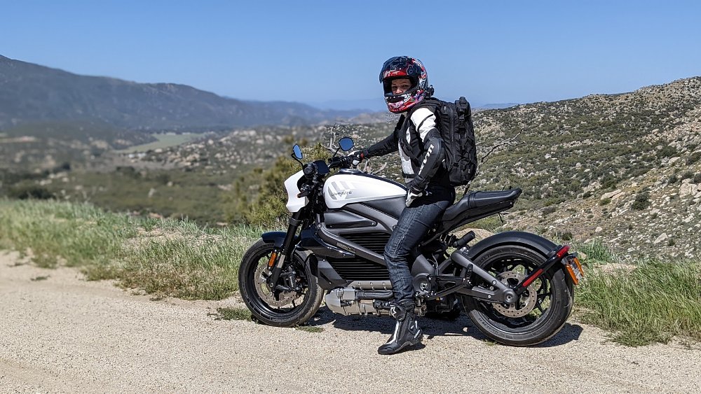 A female rider sits on the LiveWire ONE flat footed at a mountain vista