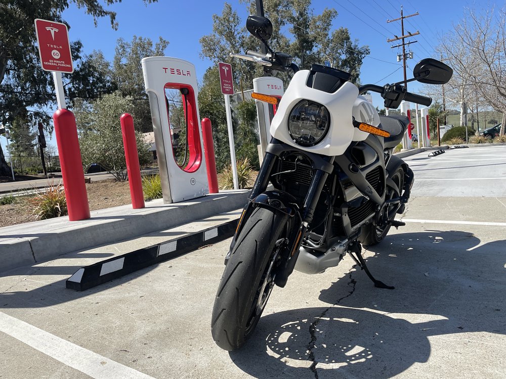 A Livewire is parked next to a Tesla charger, but it cannot charge at this station