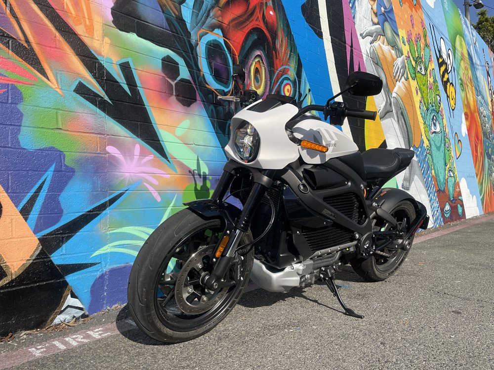A photo of the LiveWire ONE in front of a brightly colored graffiti wall