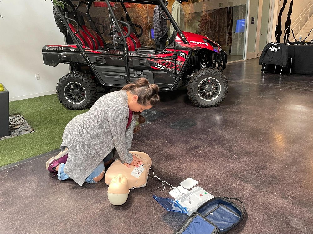 A student practices her newly learned CPR skills on a mannequin