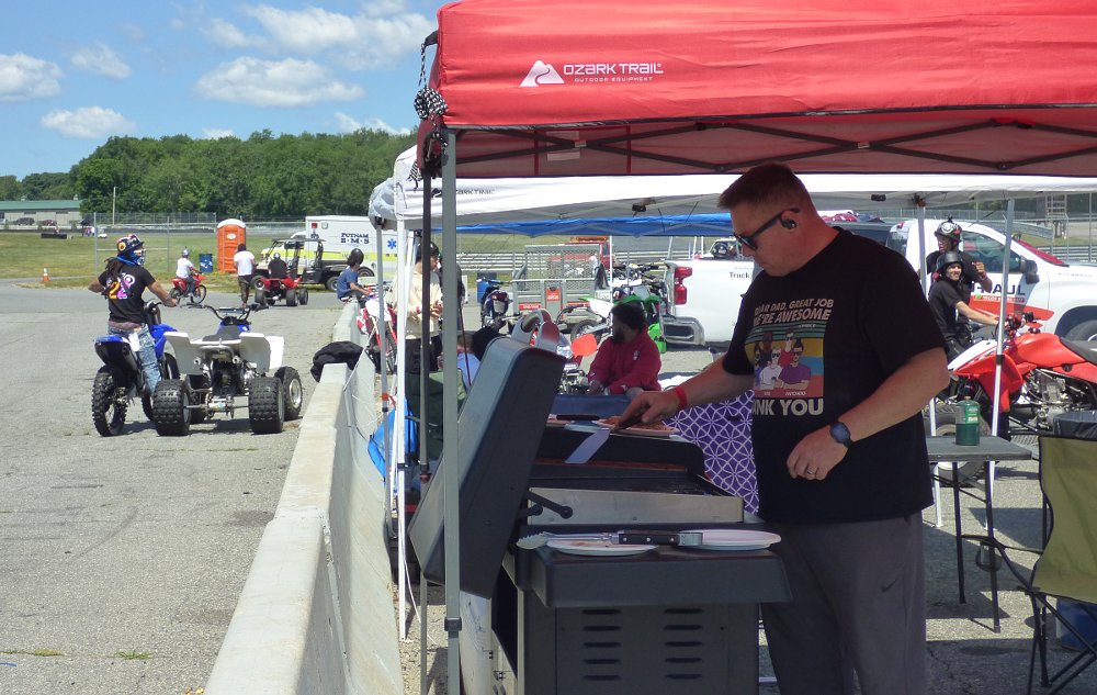 man grilling in the race paddock