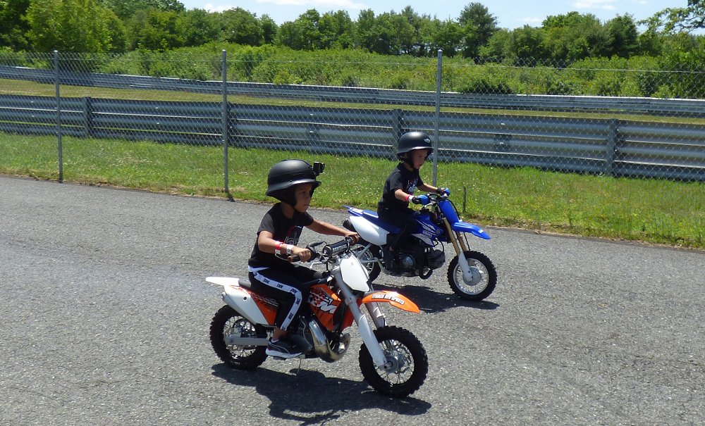 two small kids riding mini dirt bikes