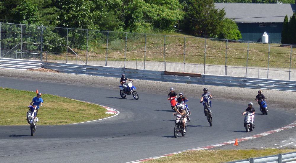 motorcycles and ATVs on the track in a group at Thompson Speedway