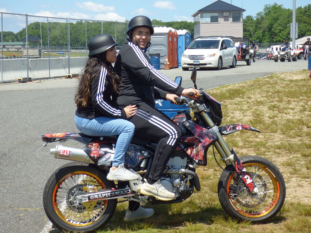 customized supermoto bike with rider and passenger in the paddock