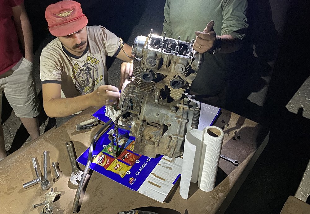 working on a disassembled engine at night