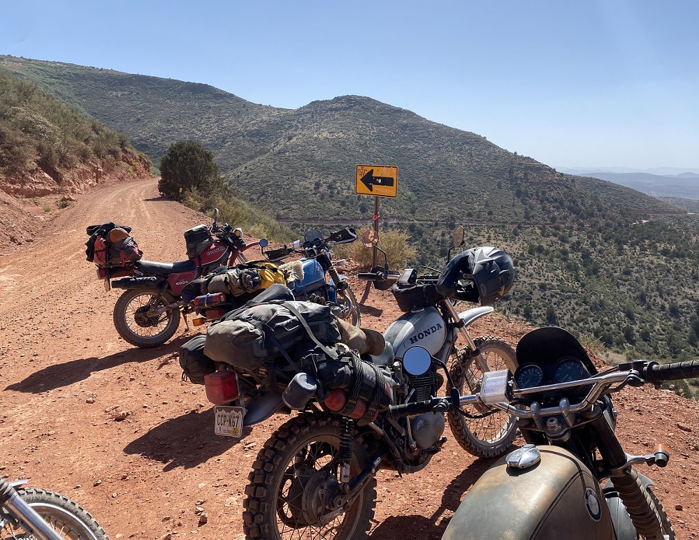 motorcycles parked at an overlook on a dirt road