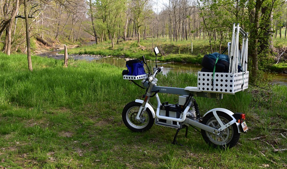 Cake Osa+ by a stream, carrying camping gear