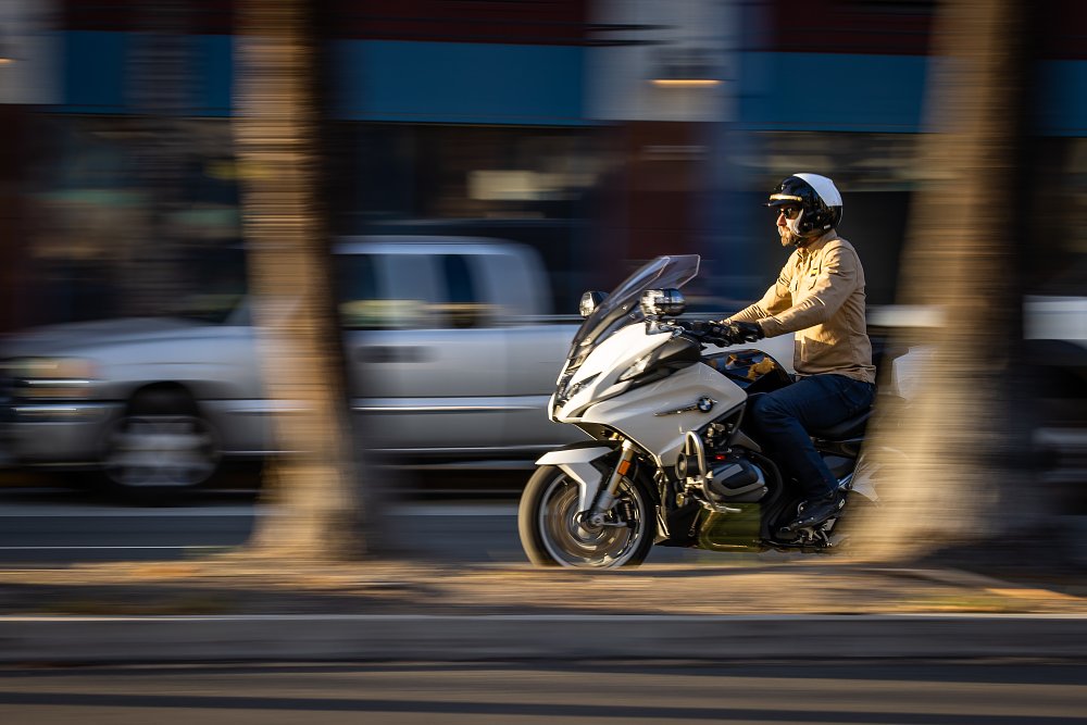 2022 BMW R 1250 RT-Police riding through a city and past palm trees.