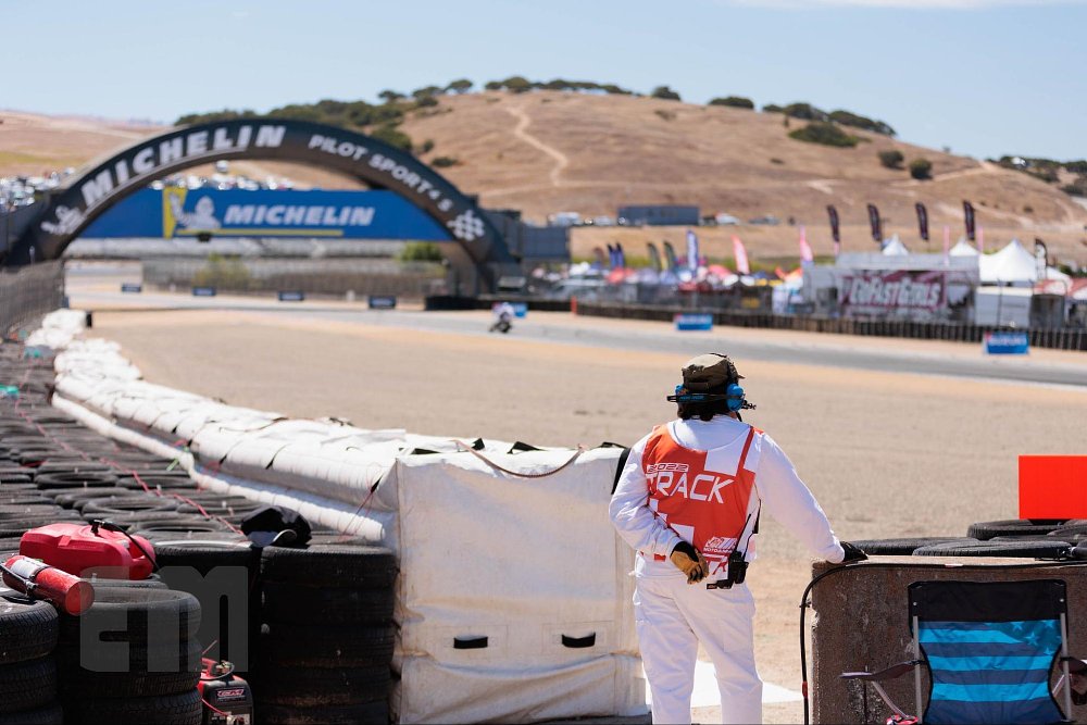 A professional corner marshal is ready on the radio in their corner at Laguna Seca raceway