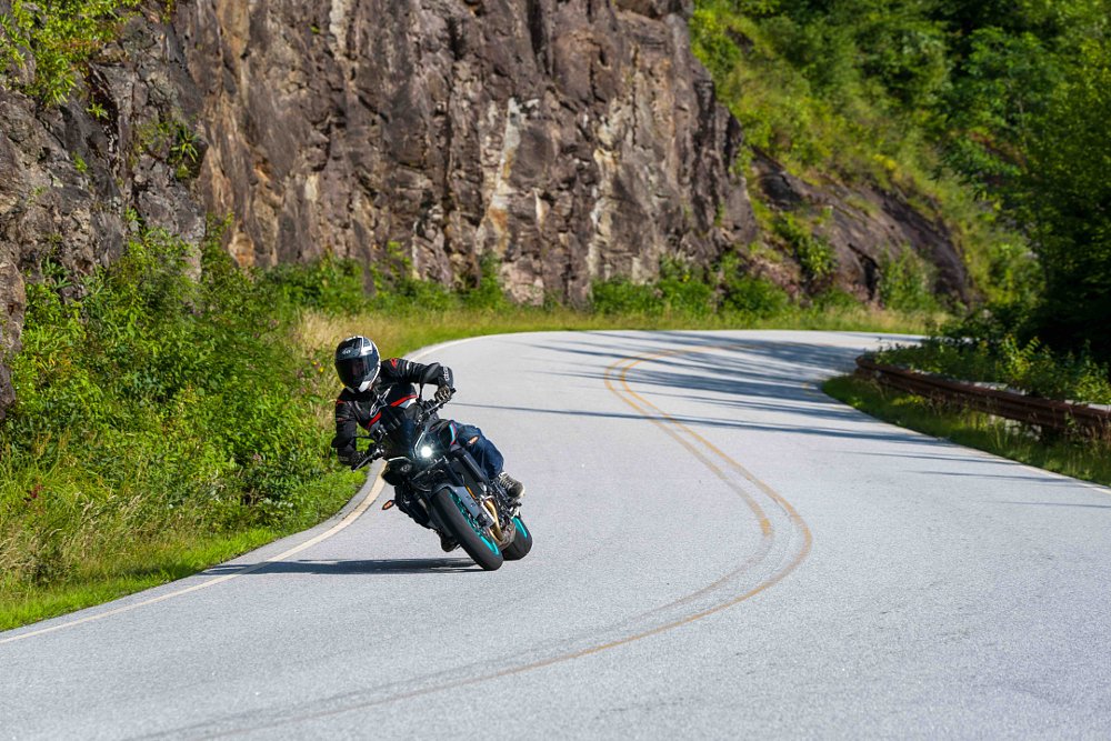 2022 Yamaha MT-10 leaning into a right turn with a rocky cliff in the background