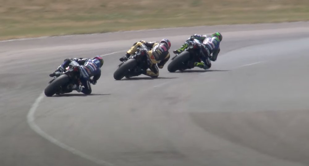 Three Yamaha YZF-R1 superbikes racing away from camera, peeling into a fast right hand curve