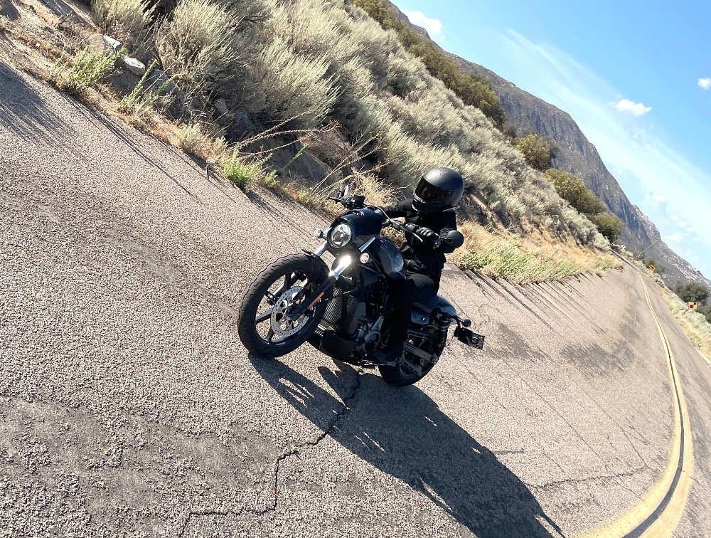 A female rider rides the H-D Nightster through a corner