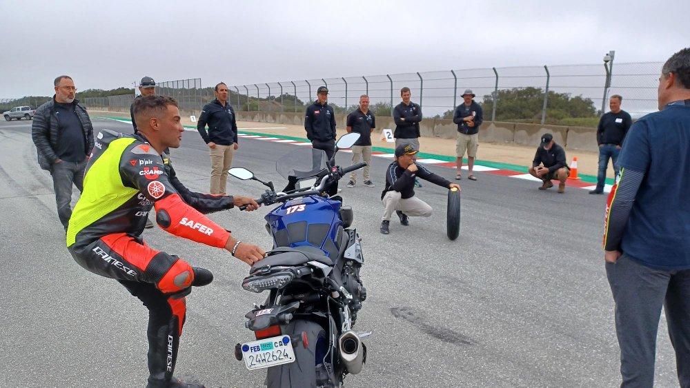 Eziah limbering up for a ride beside the motorcycle