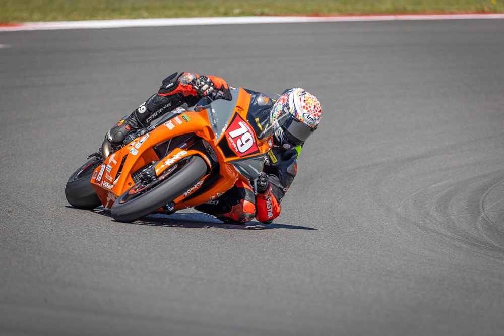 racer on the track at full lean, one finger on the brake lever