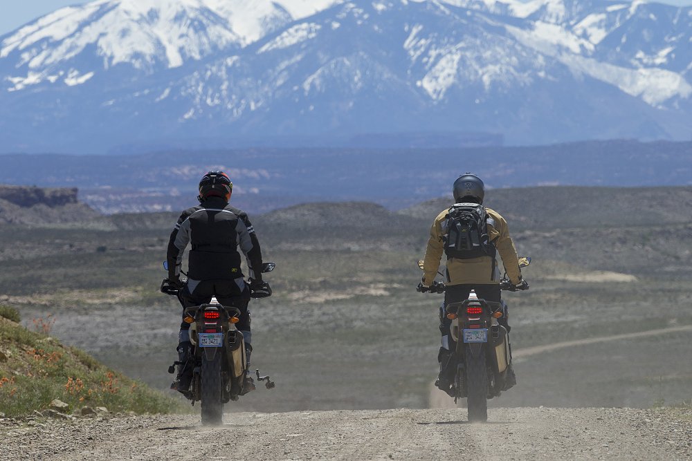 riding on a dirt road toward snowcapped mountains