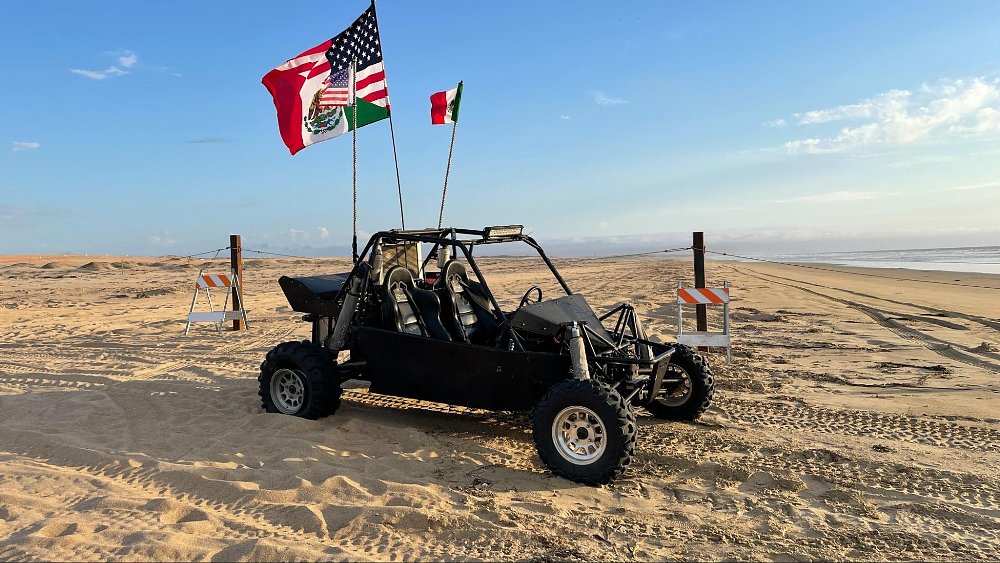 A photo of a sand rail vehicle displaying both American and Mexican flags