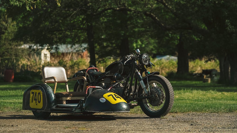 A 1965 BMW R50 /2 racing sidecar outfitted with lights and a chair on the sidecar platform.