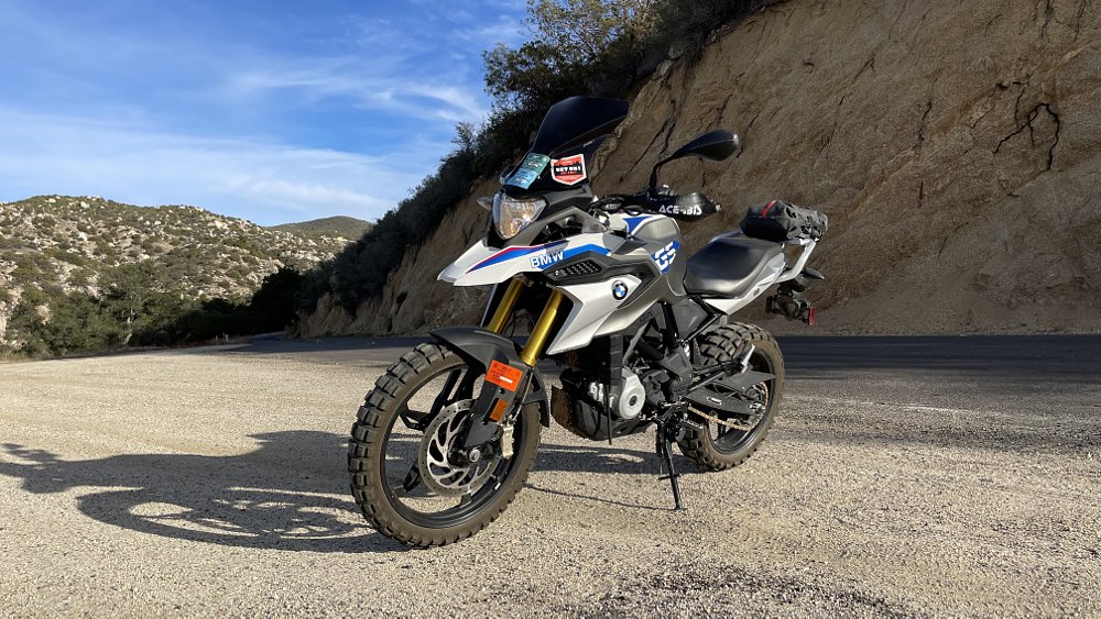 A three-quarter front view of the BMW G 310 GS parked on an outlet on a curvy mountain road