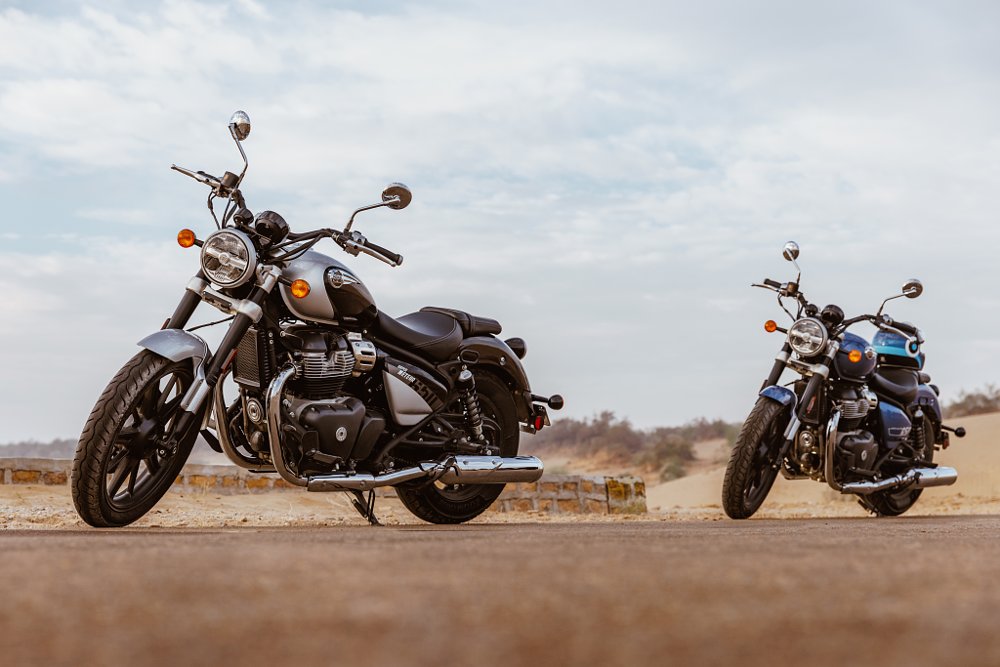 Two Super Meteor 650 in a desert landscape, one cherry red and the other forest green