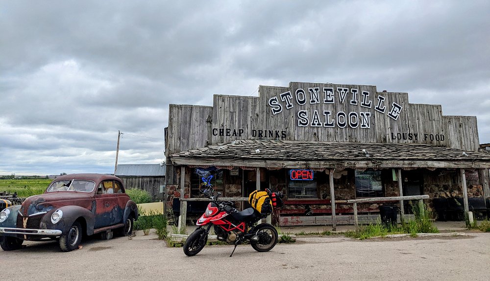 Ducati parked in front of an old, weathered, western saloon