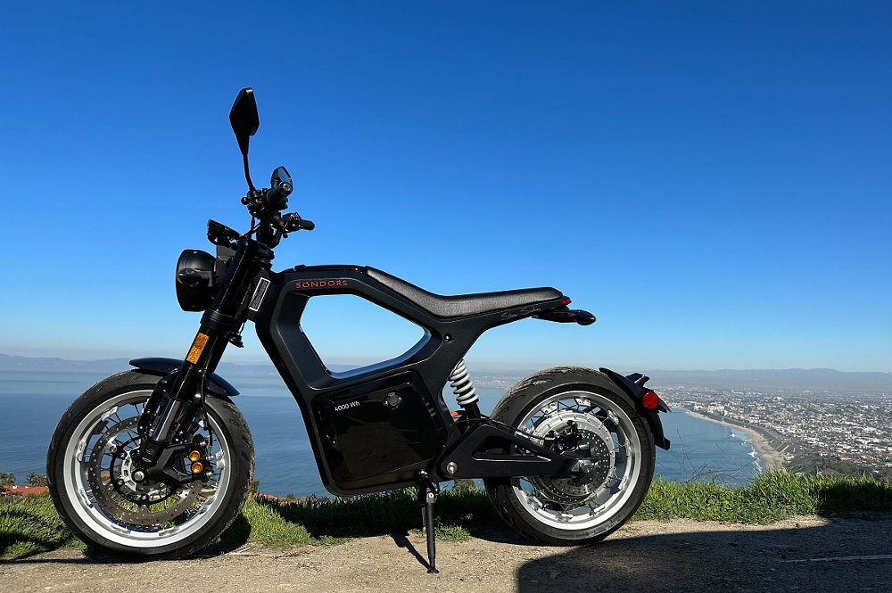 black Sondors MetaCycle parked on an overlook above the Pacific Ocean