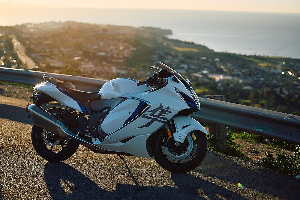 2023 Suzuki Hayabusa backlit at sunrise, ocean in the background.