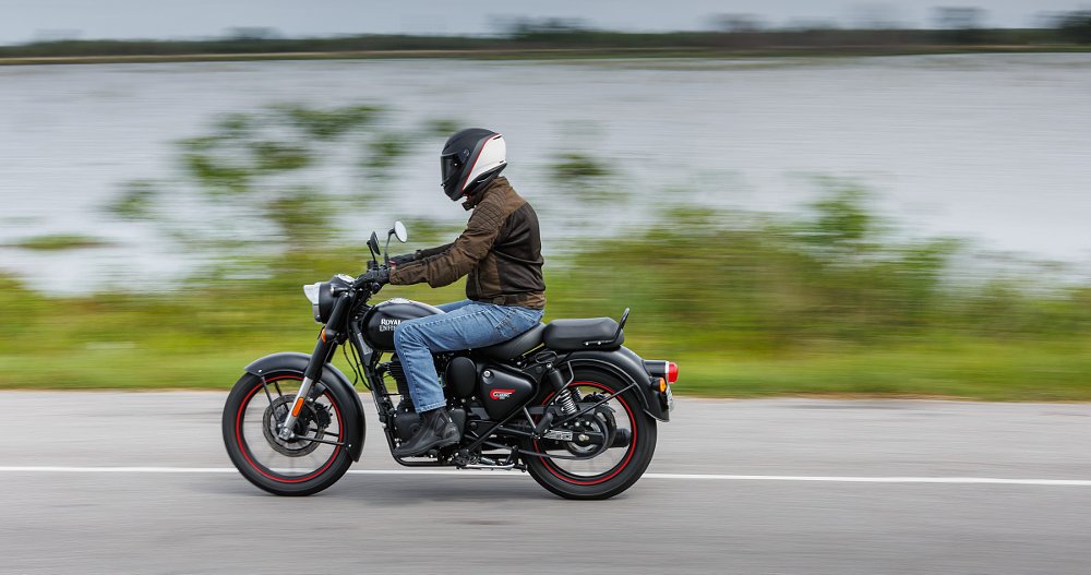 rider on a Royal Enfield Classic 350 by a lake