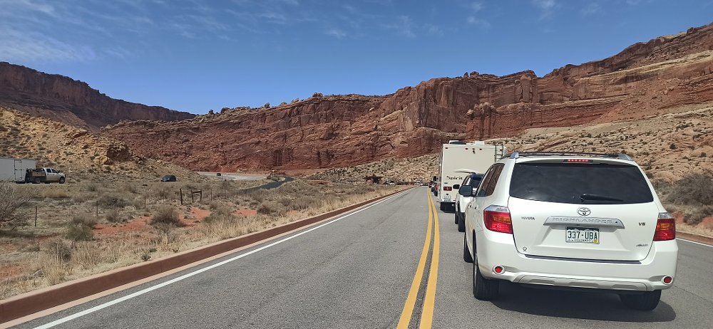 a line of cars and recreational vehicles at a park entrance