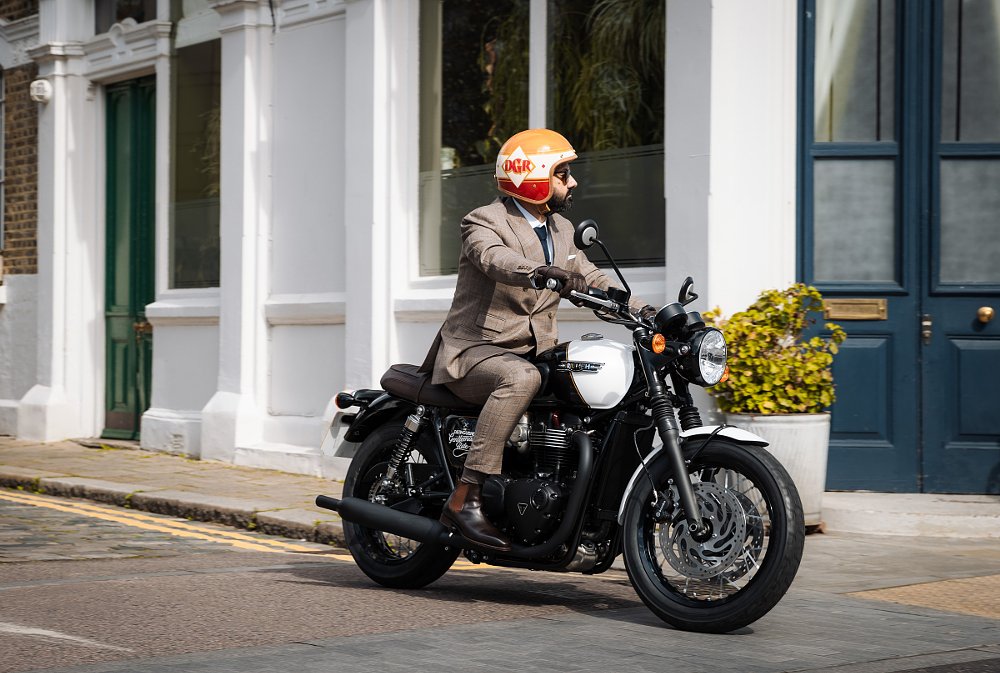 Mark Hawwa wearing a suit and riding the motorcycle