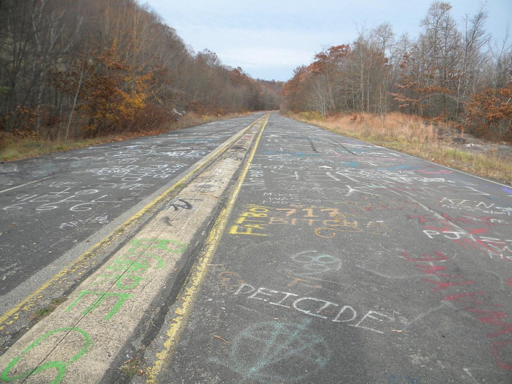 abandoned road covered in spray paint graffiti