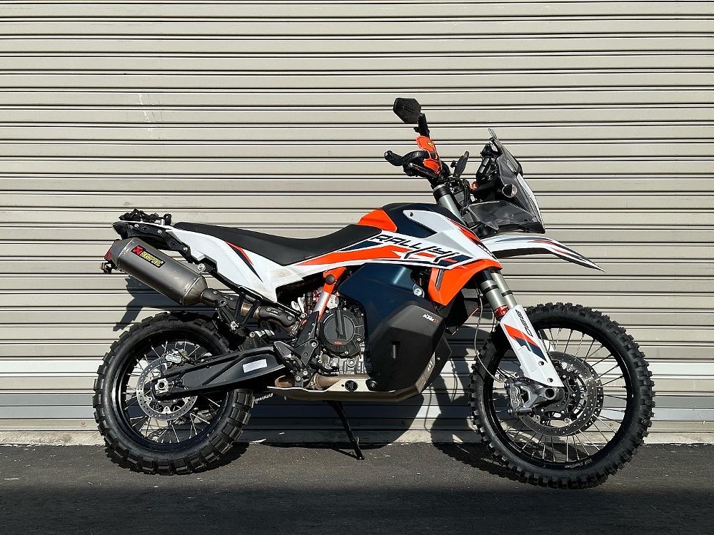 2021 KTM 890 Adventure R Rally parked against an industrial garage door.