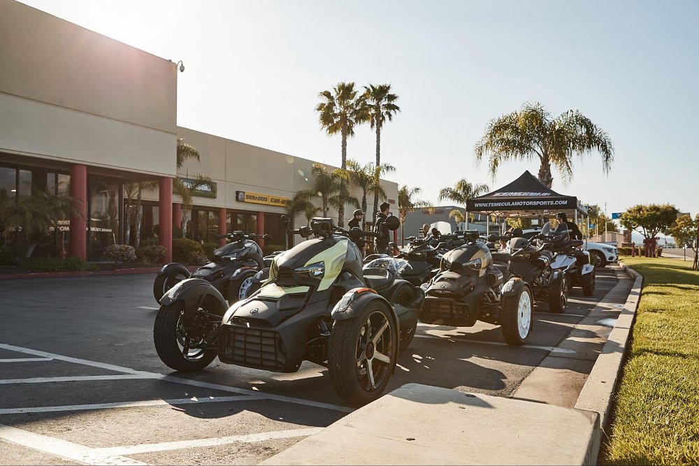 a wide assortment of models and colors of can-am 3 wheels parked in parking lot