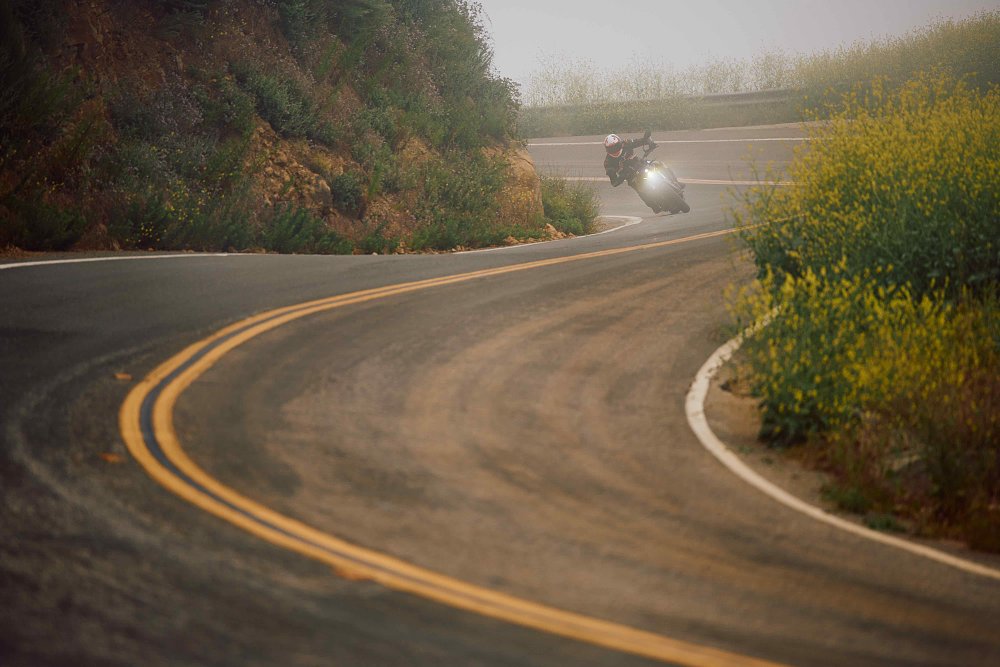 2023 Suzuki GSX-8S carving through a foggy canyon toward the camera.
