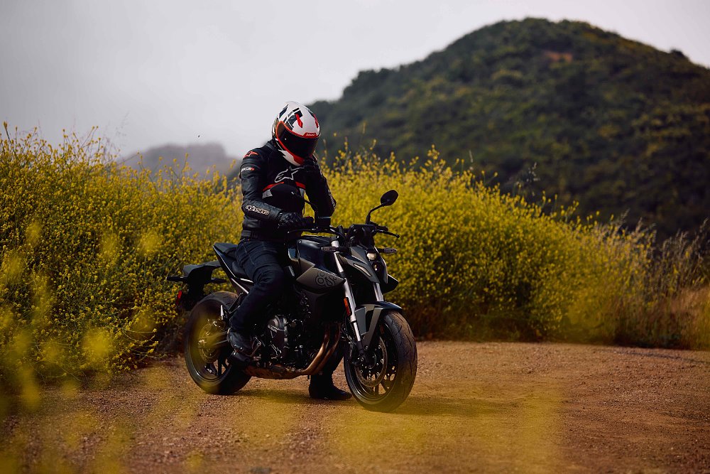 2023 Suzuki GSX-8S sitting in a dirt parking lot with a rider on board.