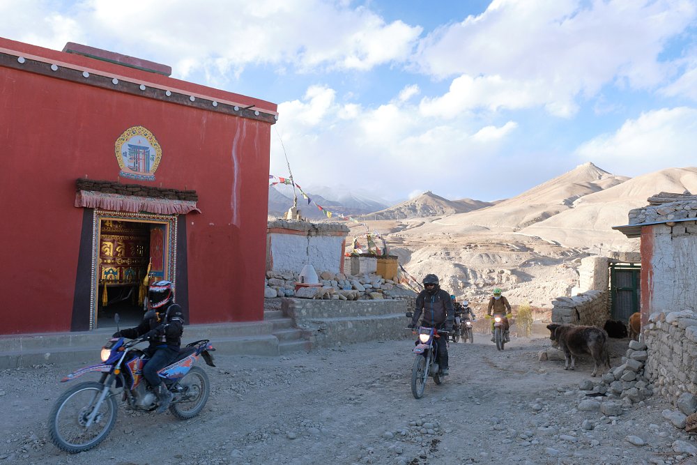 riders passing buildings in rural Nepal