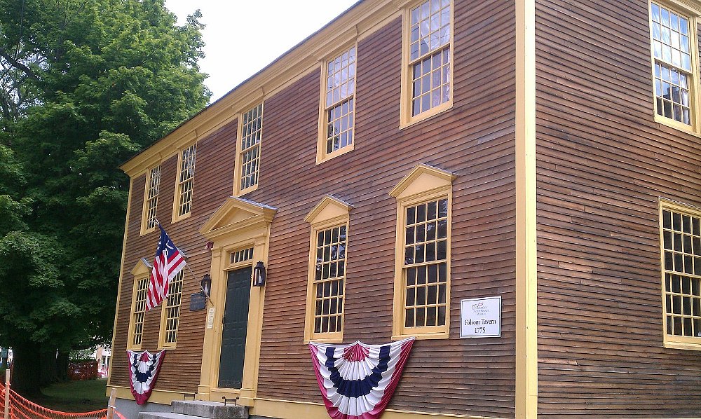 A photo of the Folsom Tavern front facade that has colonial shutter windows and brown facing shingles