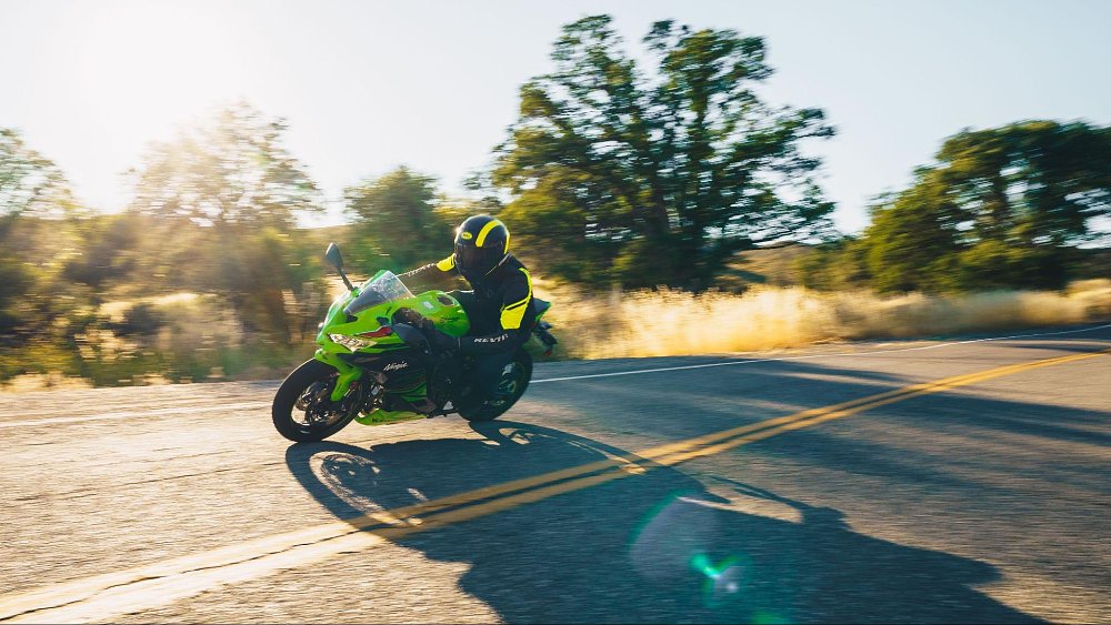 An action photo of the ZX-4RR riding around a sunset corner on a quiet country road