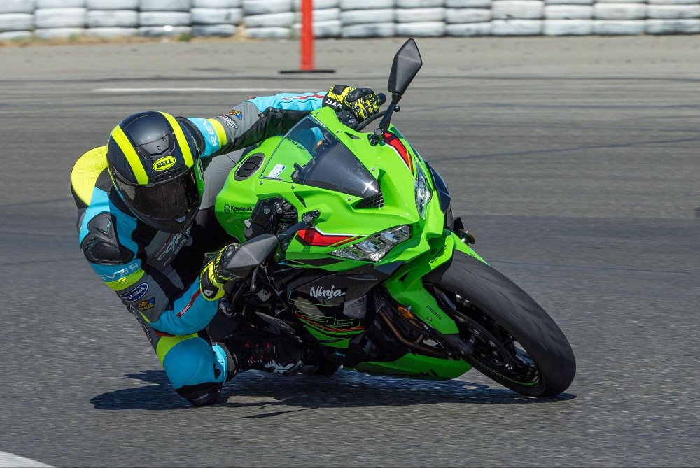 A male rider dragging his knee on the race track on board the ninja zx-4rr