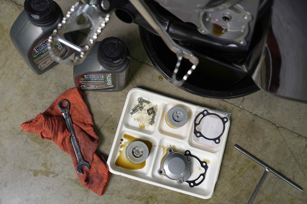 Paper tray used for organizing parts during an oil change on a motorcycle.