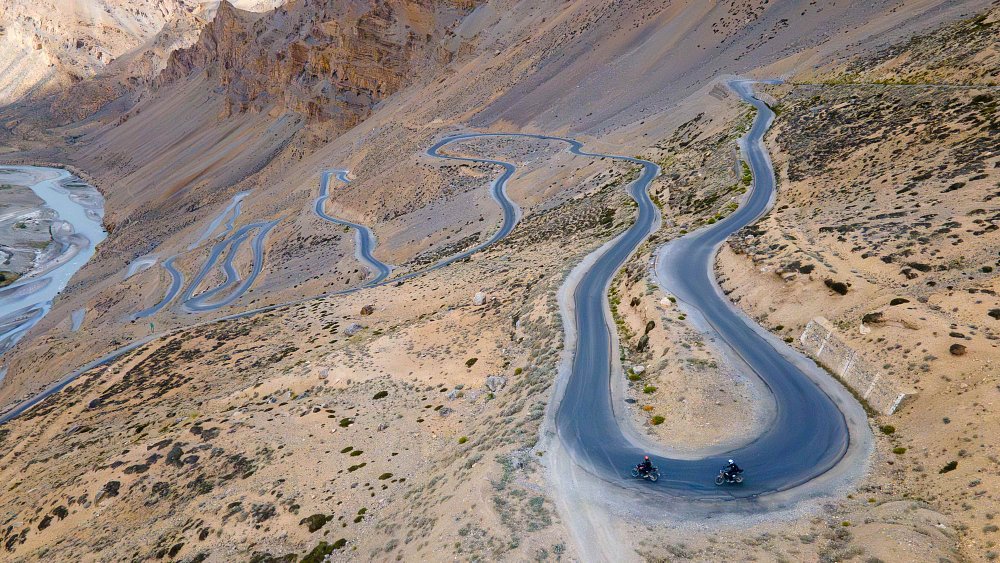 Two motorcycles ride down the Gata Loops, on India's NH3, in the Ladakh region.