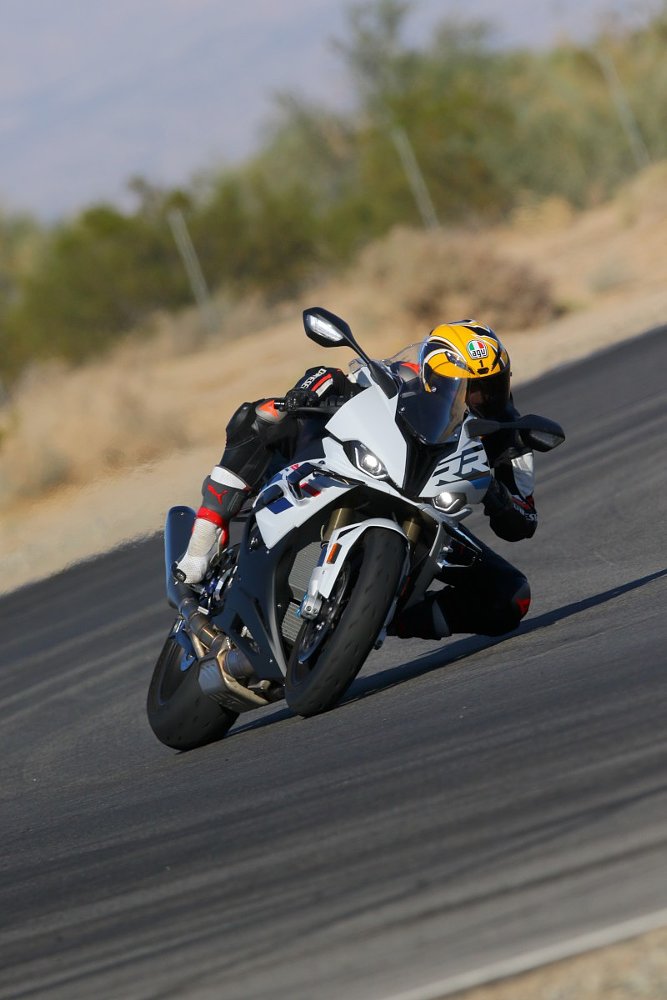 A female rider is dragging knee on the race track on board the BMW S 1000 RR superbike