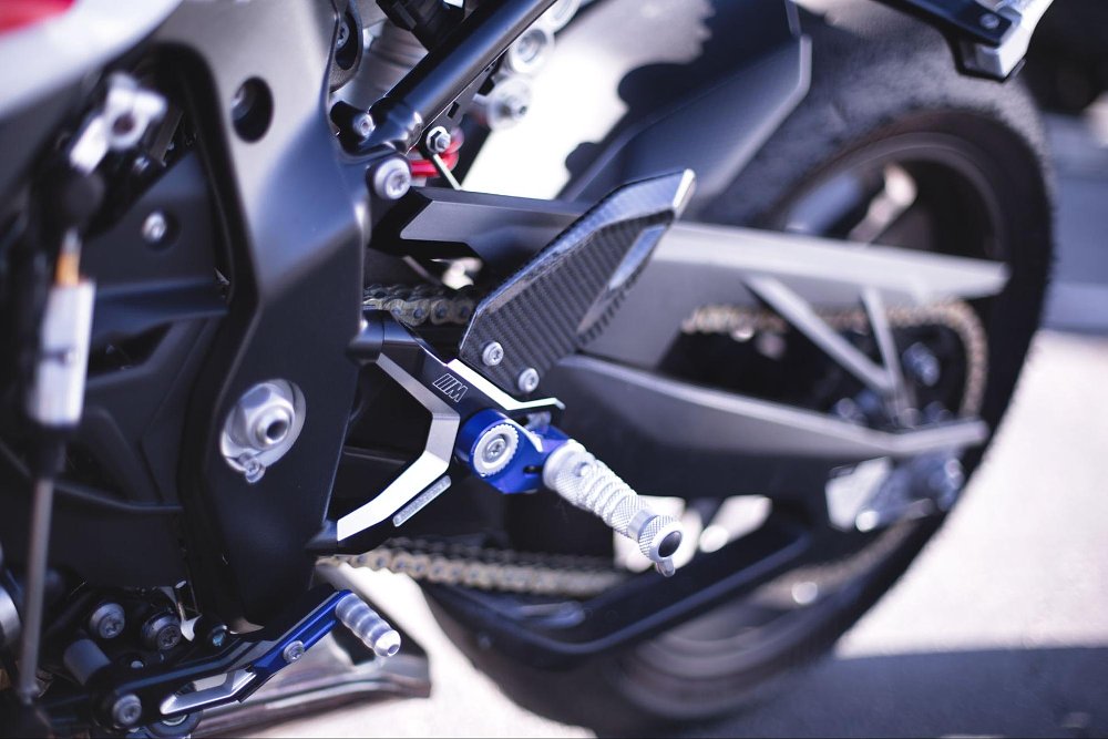 A close up the billet machined and anodized blue adjustable rear set foot pegs on BMW S 1000 RR