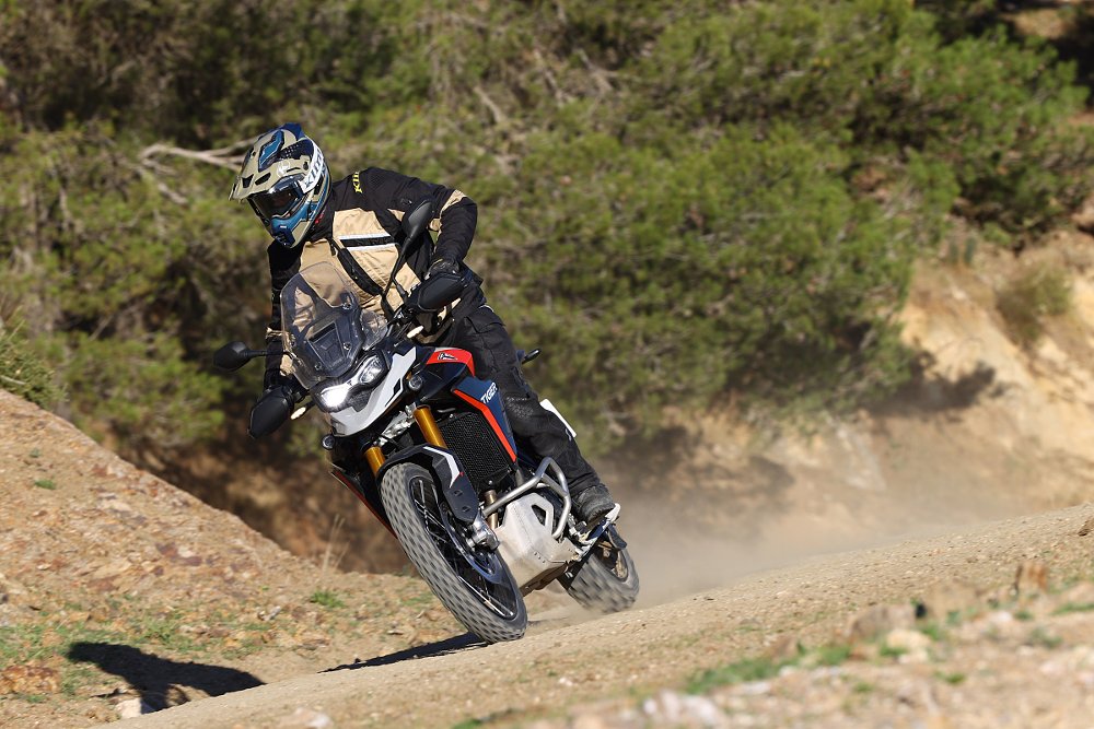 riding the Triumph Tiger 900 GT Pro on a dirt road in Spain