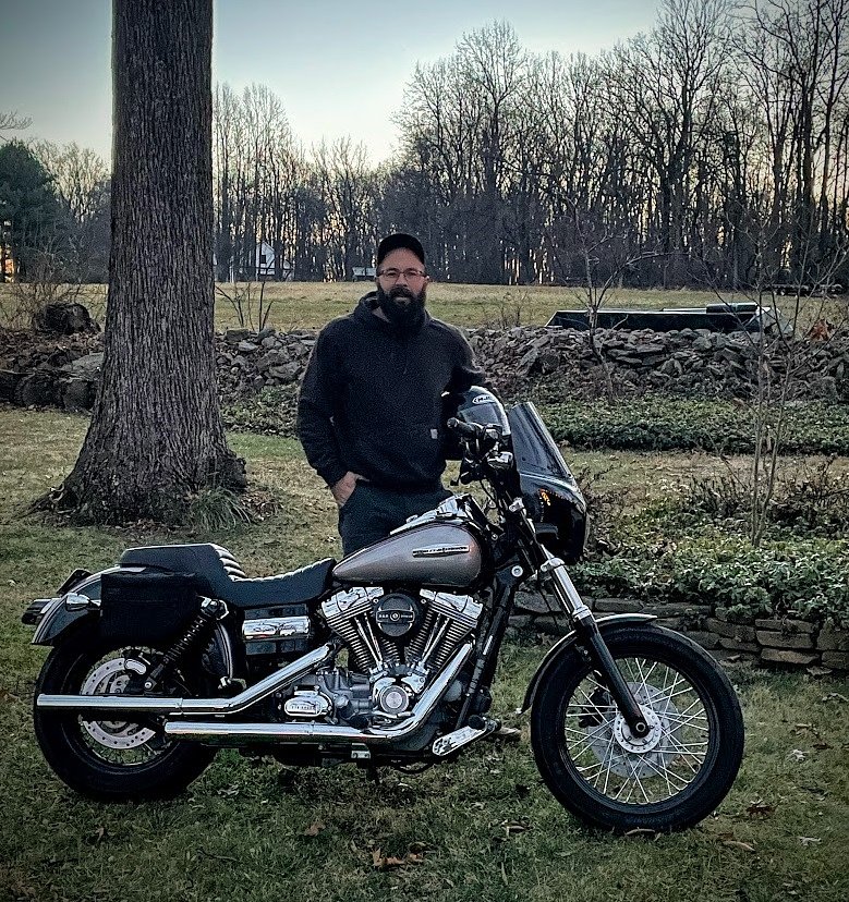 Nate standing behind his modern Harley-Davidson motorcycle