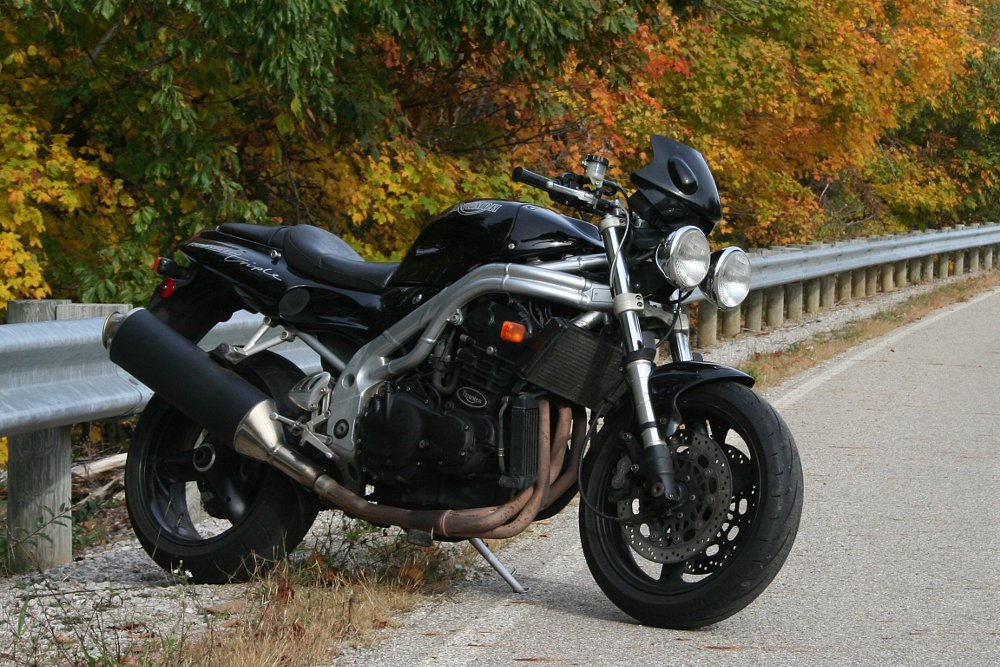 black Speed Triple parked along a road in autumn