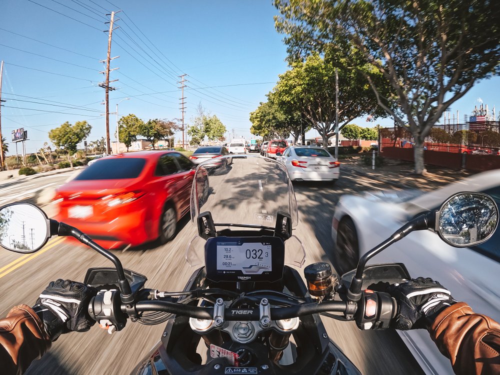 motorcyclist riding between lanes of cars